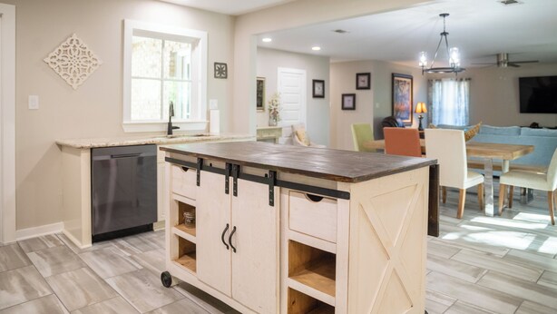 A kitchen with a central island, a dishwasher, and a dining area with a table and chairs. - 3BR/2.5BA close to Beach, Casinos & Downtown Ocean Springs! Shorebound (Ocean Springs)