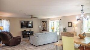 A living room with a sofa, armchair, dining table, and chairs. - 3BR/2.5BA close to Beach, Casinos & Downtown Ocean Springs! Shorebound (Ocean Springs)