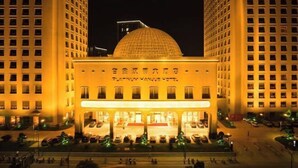 Un hotel con una cúpula destacada y una entrada amplia.