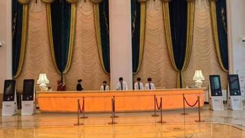 A reception area with a marble floor, a reception desk, and curtains.