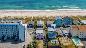 An aerial view of a coastal hotel with multiple buildings, a beach, and a swimming pool. - Beach Breeze by Carolina Retreats (Carolina Beach)