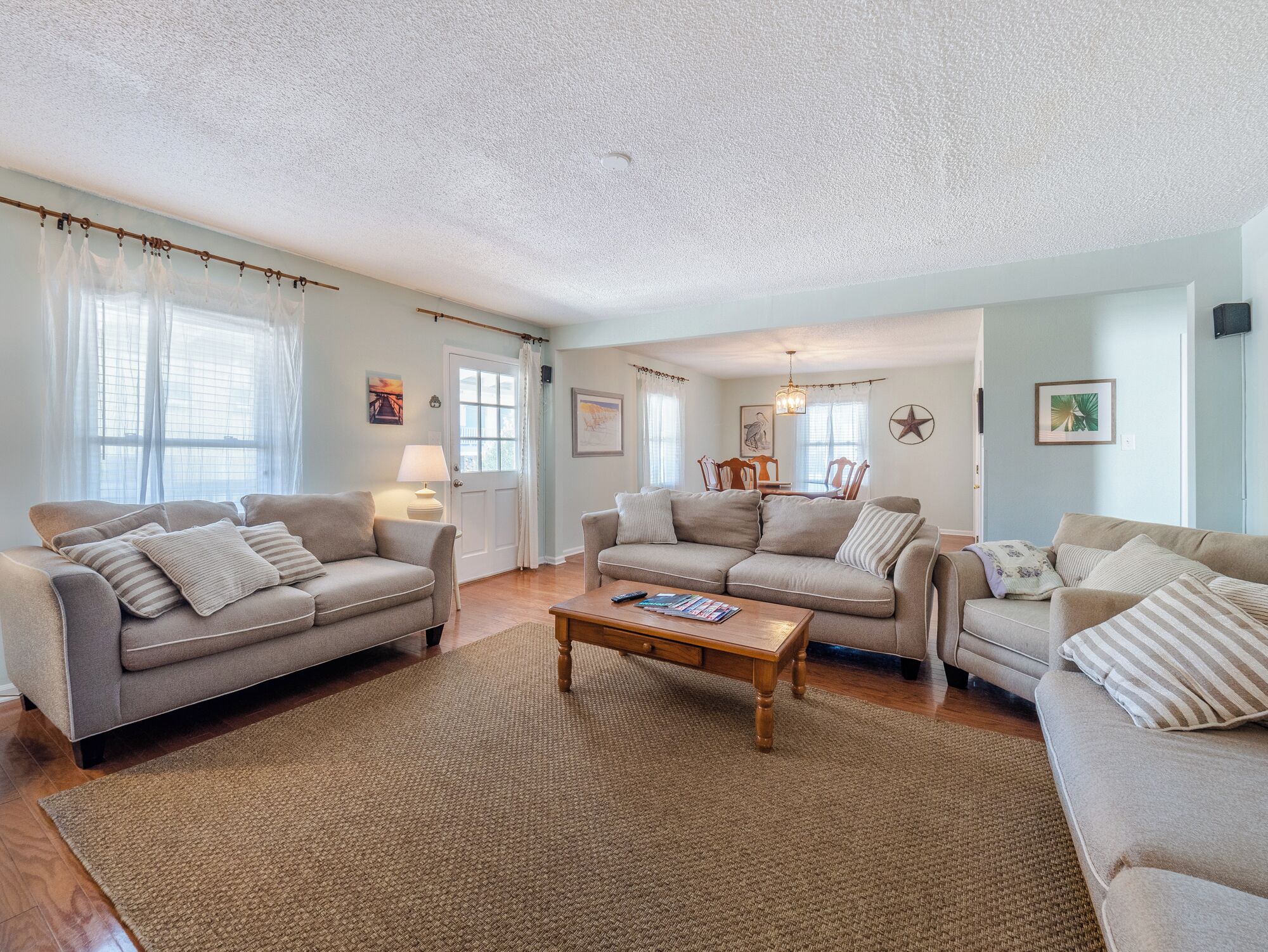 A spacious living room with two sofas, a coffee table, and a dining area with chairs and a table.