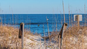 A wooden boardwalk leading to a beach with a clear view of the ocean. - No Worries in Paradise (Carolina Beach)