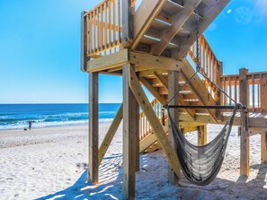 A wooden beach structure with a hammock and a staircase leading to a platform. - Vintage Vacation by Topsail Realty (Holly Ridge)