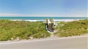 A beachside view with a wooden structure, possibly a beach chair or a small deck, near the ocean. - Sea Angels by Topsail Realty (Holly Ridge)