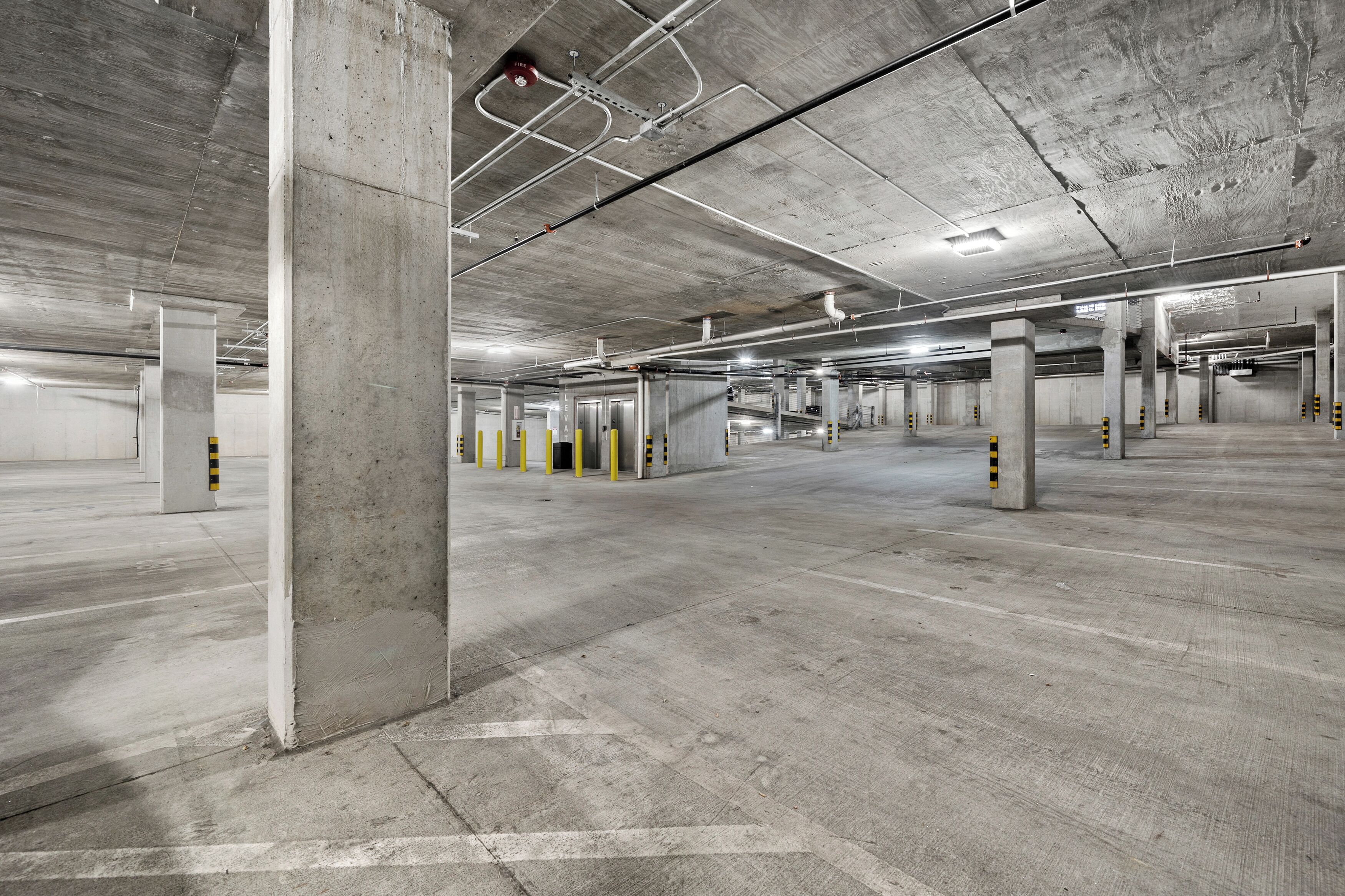 A multi-level parking garage with concrete pillars and marked parking spaces.