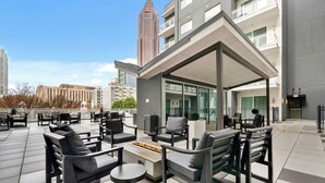 A rooftop lounge with outdoor seating and a fire feature. - Dorsen Stay (Atlanta)