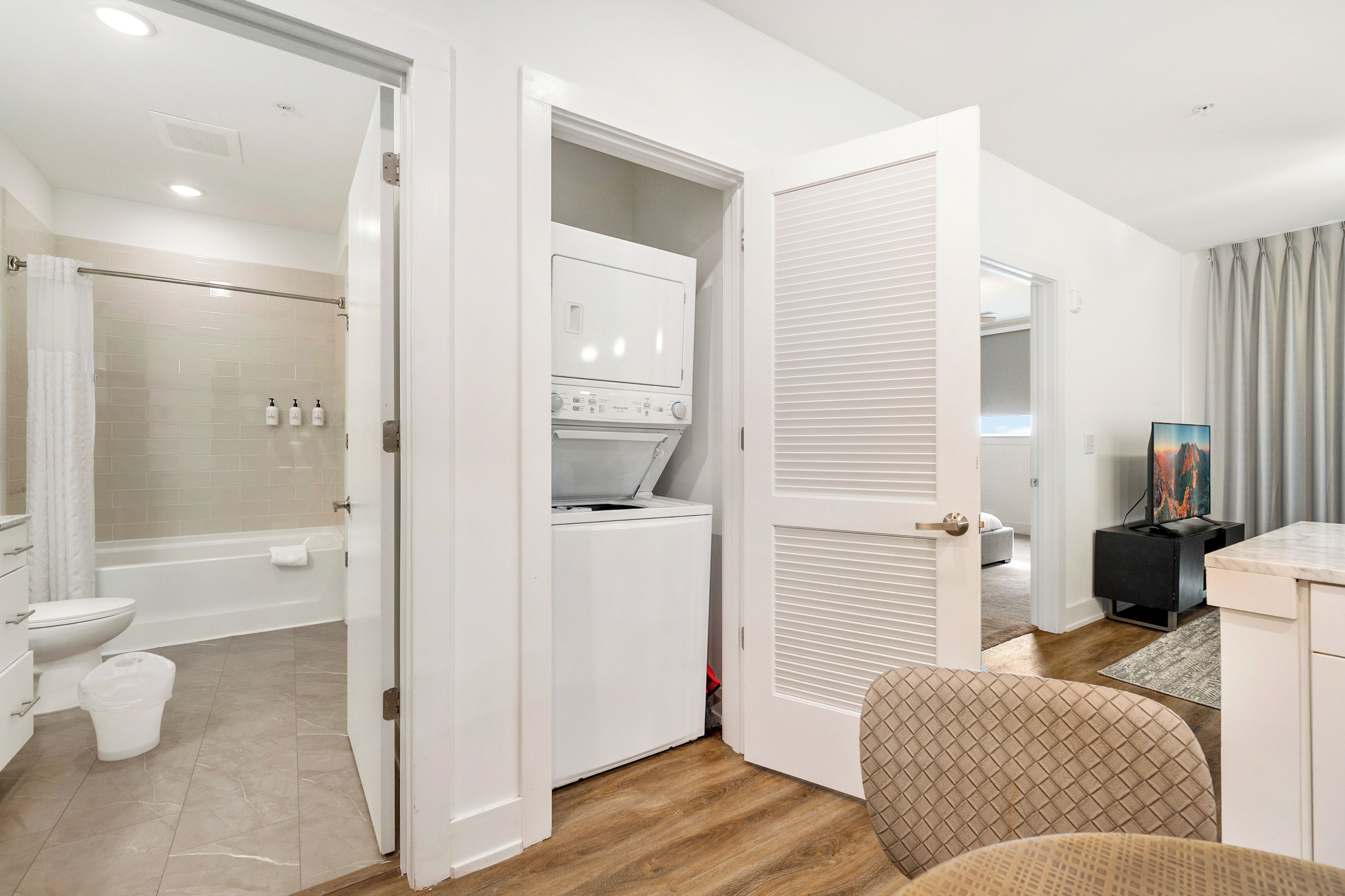 A modern bathroom with a shower, toilet, and a built-in washing machine.