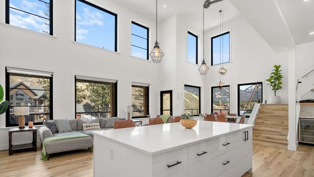 A spacious living area with a large island, multiple windows, and a view of the outdoors. - Salt & Stone | Lake/Private Beach | Mountain Views (Invermere)