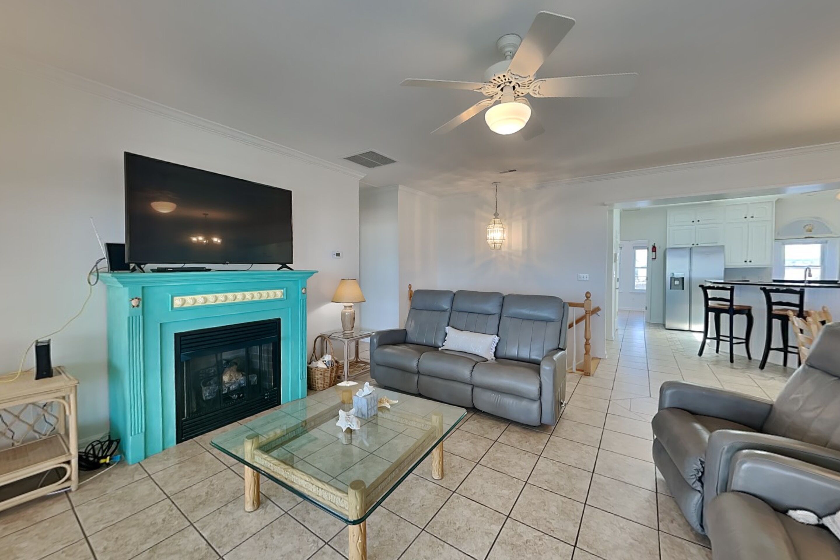 A living room with a fireplace, a sofa, a coffee table, and a television.