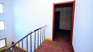 A staircase with a metal railing, a patterned carpet, and a door leading to another room. - Kangbao Hotel (Xuzhou)