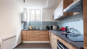 Eine moderne Küche mit Holzausstattung, einer schwarzen Arbeitsplatte und einem eingebauten Backofen.