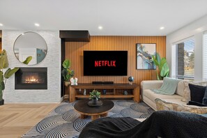 Smart TV, caminetto, libri, impianto stereo
