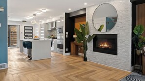 Une cuisine moderne avec des meubles blancs, un îlot central et un four encastré.