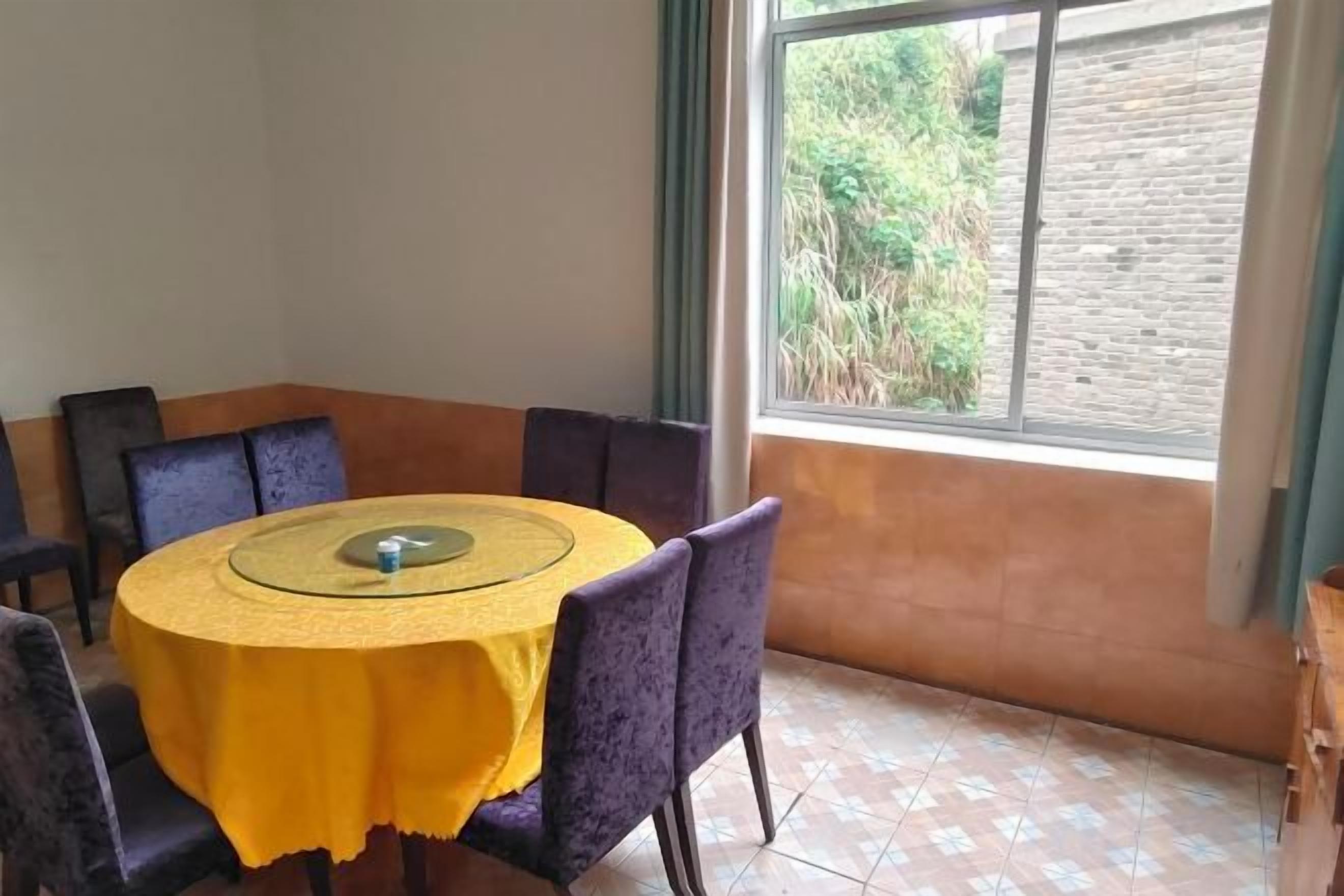Comedor con una mesa redonda, sillas y ventana con vistas a zonas verdes.
