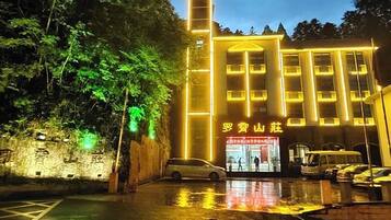 A building with a prominent vertical structure and a sign with Chinese characters.