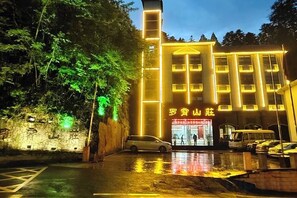 A building with a prominent vertical structure and a sign with Chinese characters.