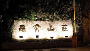 A wall with illuminated Chinese characters, surrounded by greenery. - Luoxiao Mountain Villa Jinggangshan (Jinggangshan City)