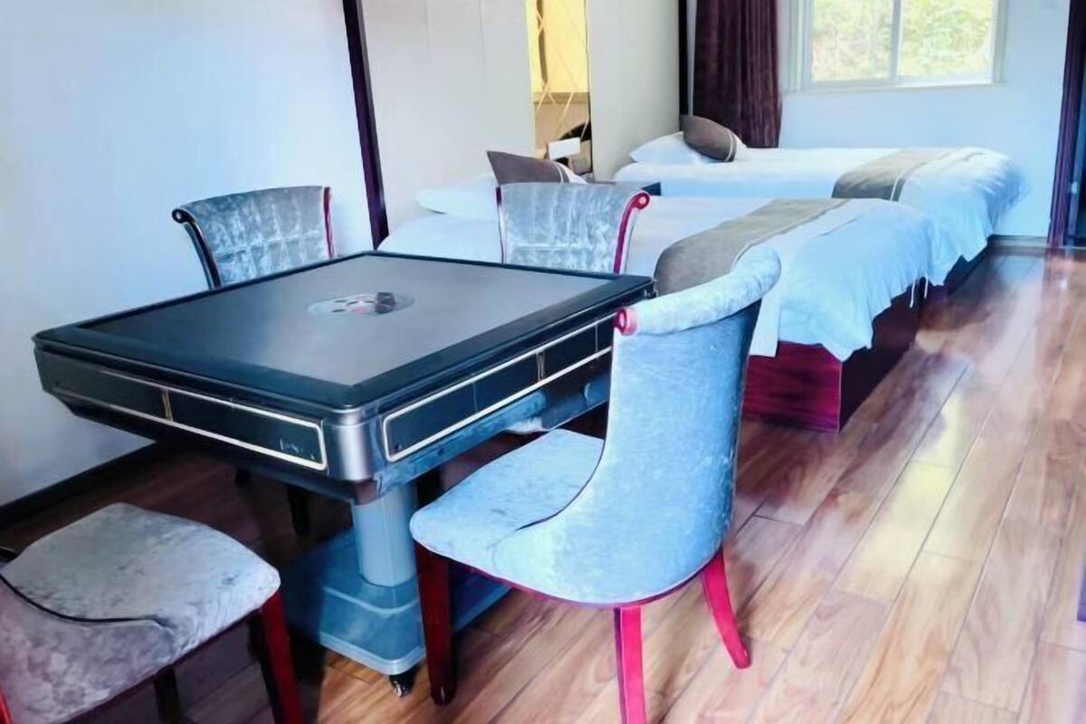 A room with a bed, a desk, and two chairs.