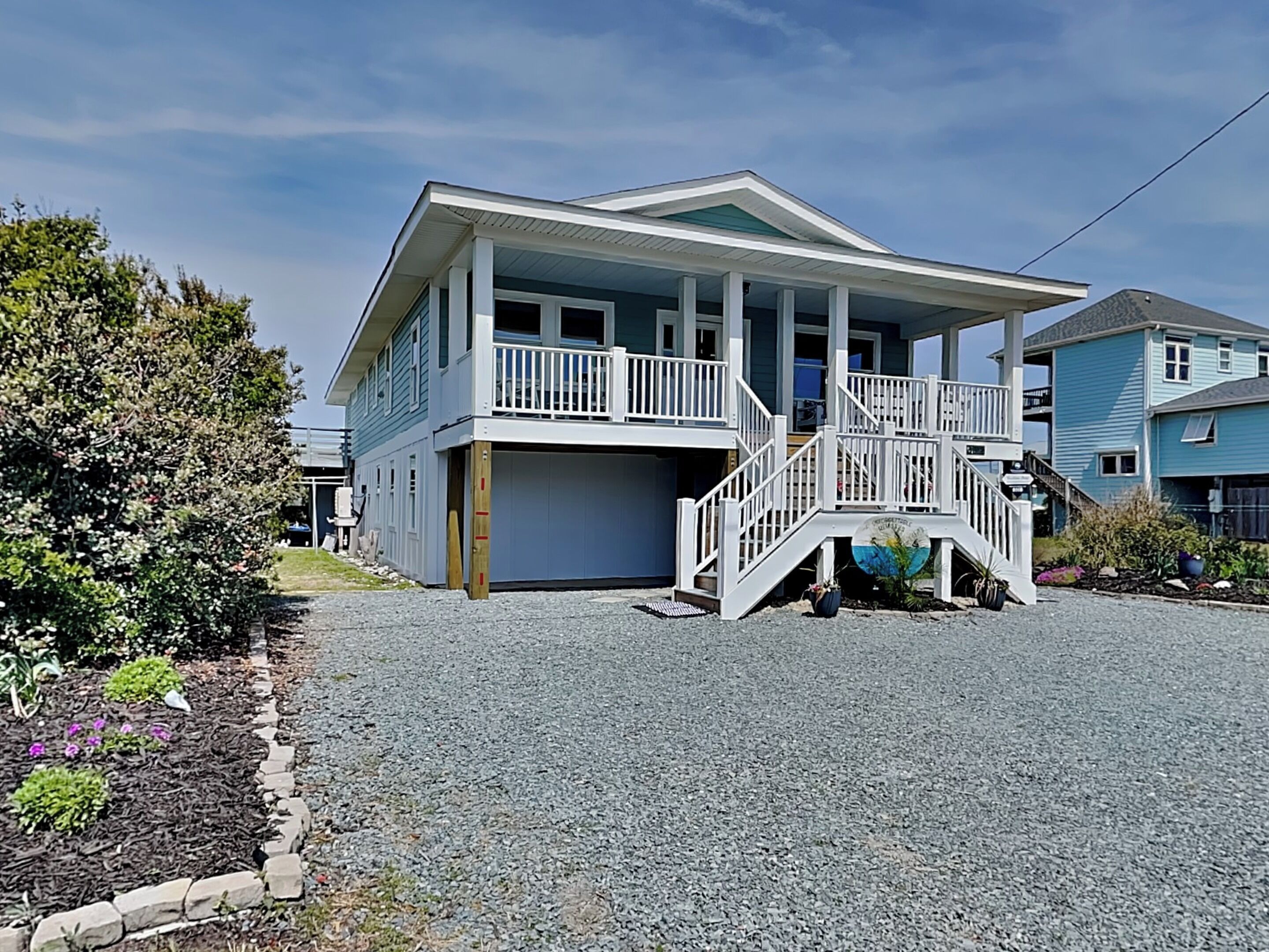 A two-story house with a covered porch and a staircase leading to the upper level.