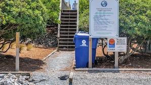 A public beach access sign, a trash bin, and a wooden staircase leading to a beach. - Perfectly Tangy by Topsail Realty (Holly Ridge)