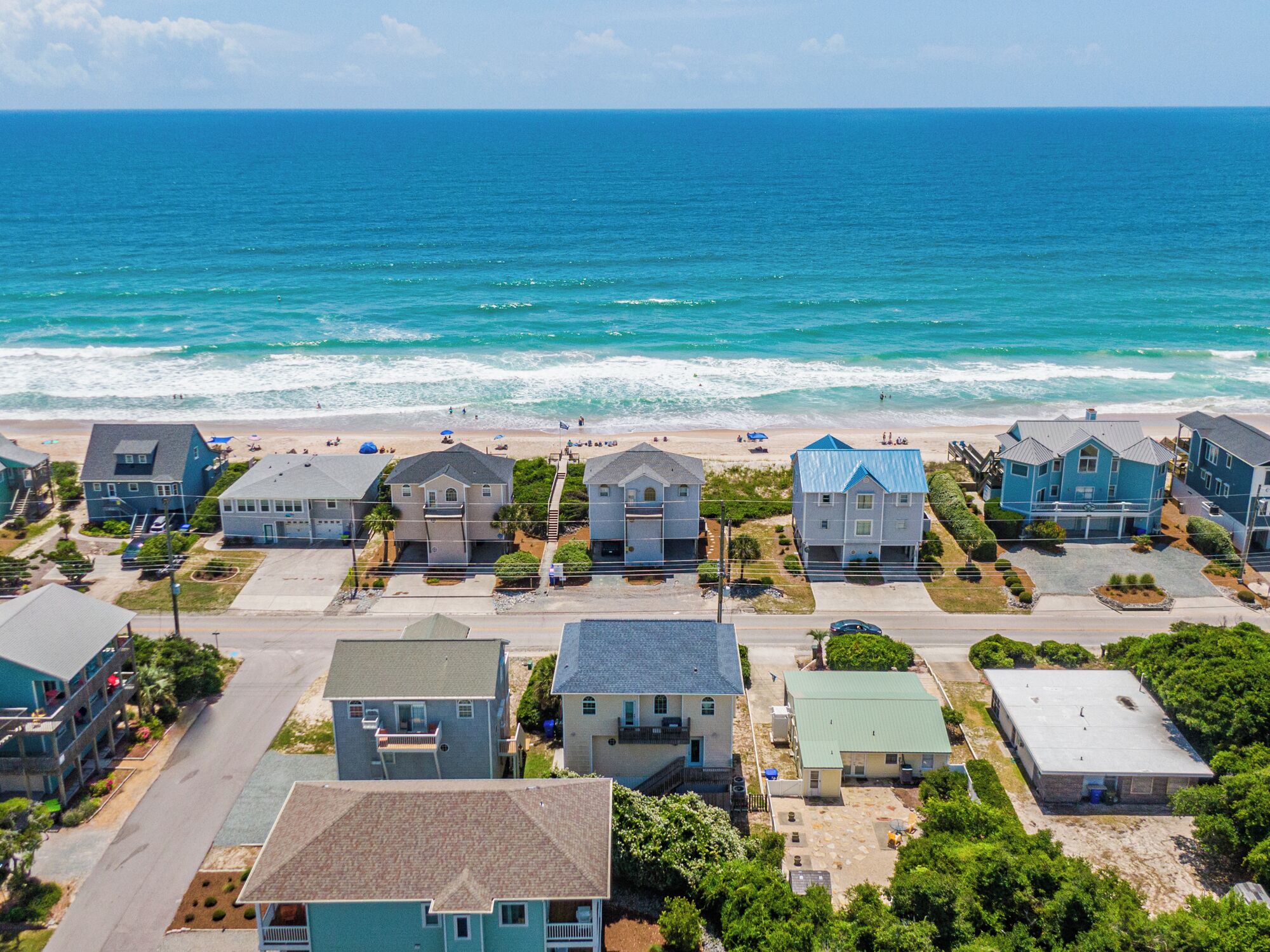 A coastal residential area with houses, a beach, and the ocean.