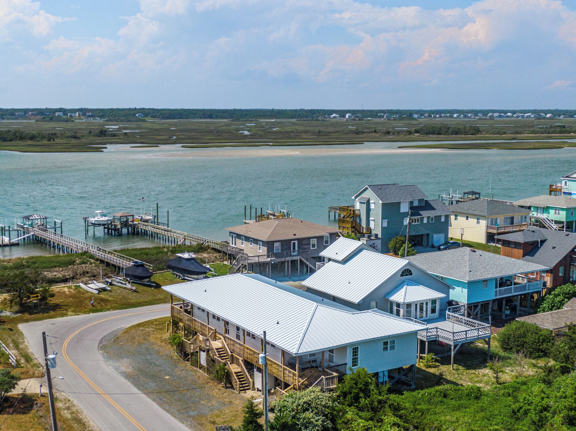 A coastal residential area with houses, a dock, and a road.
