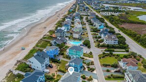 A coastal residential area with houses, a beach, and a swimming pool. - Summer Wynd by Topsail Realty (Sneads Ferry)