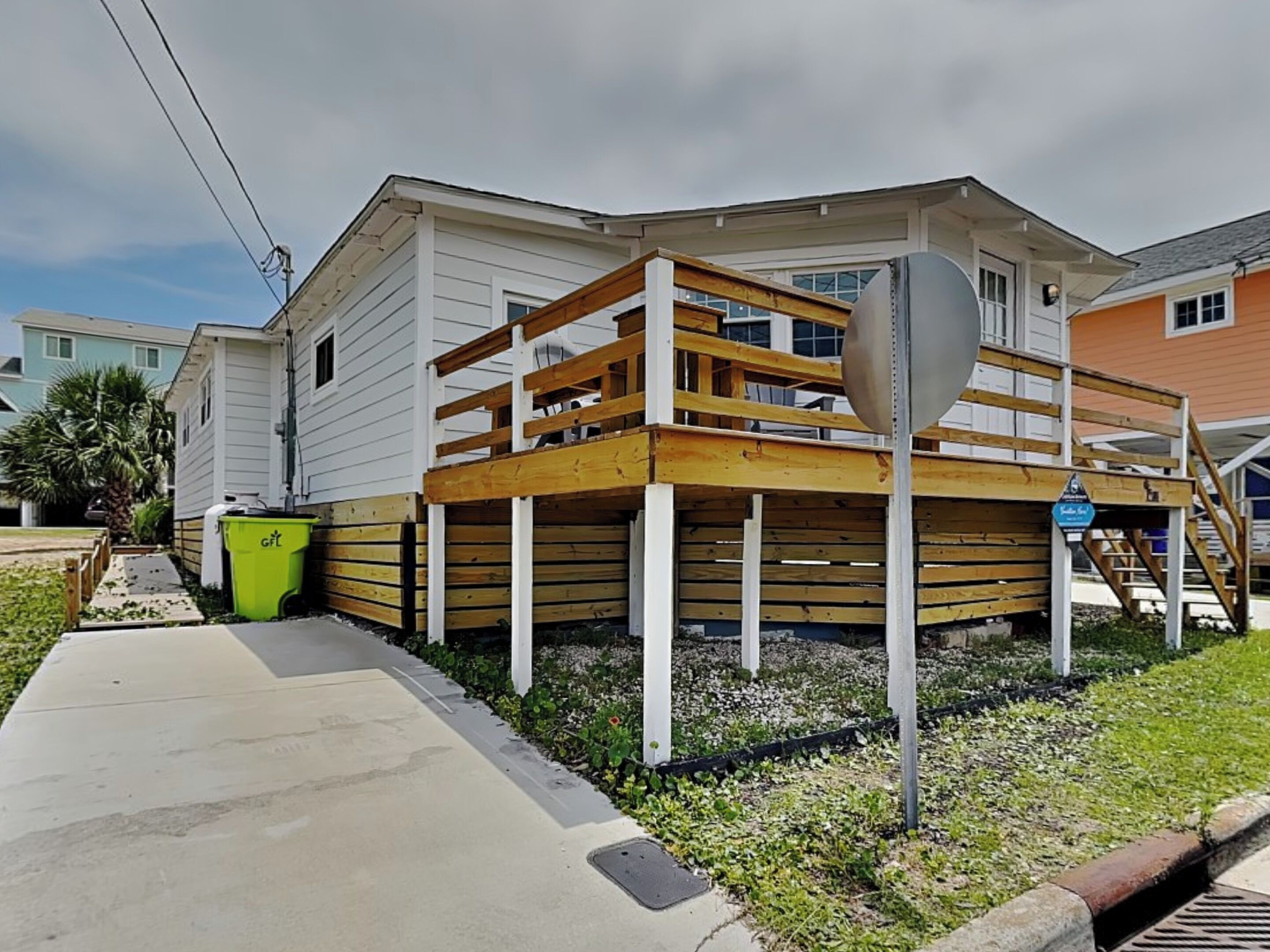 A two-story house with a wooden deck and a single-story extension.