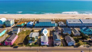 An aerial view of a coastal residential area with houses and a beach. - Toes in the Sand by Carolina Retreats (Carolina Beach)