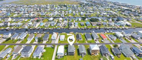 An aerial view of a residential area with houses, a marina, and a large body of water.