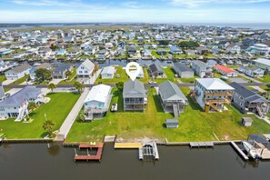 An aerial view of a residential area with houses, a dock, and a marina.