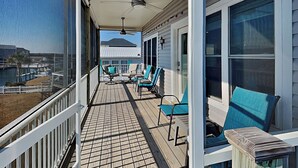 Een overdekt balkon met uitzicht op een gebouw en een waterpartij.