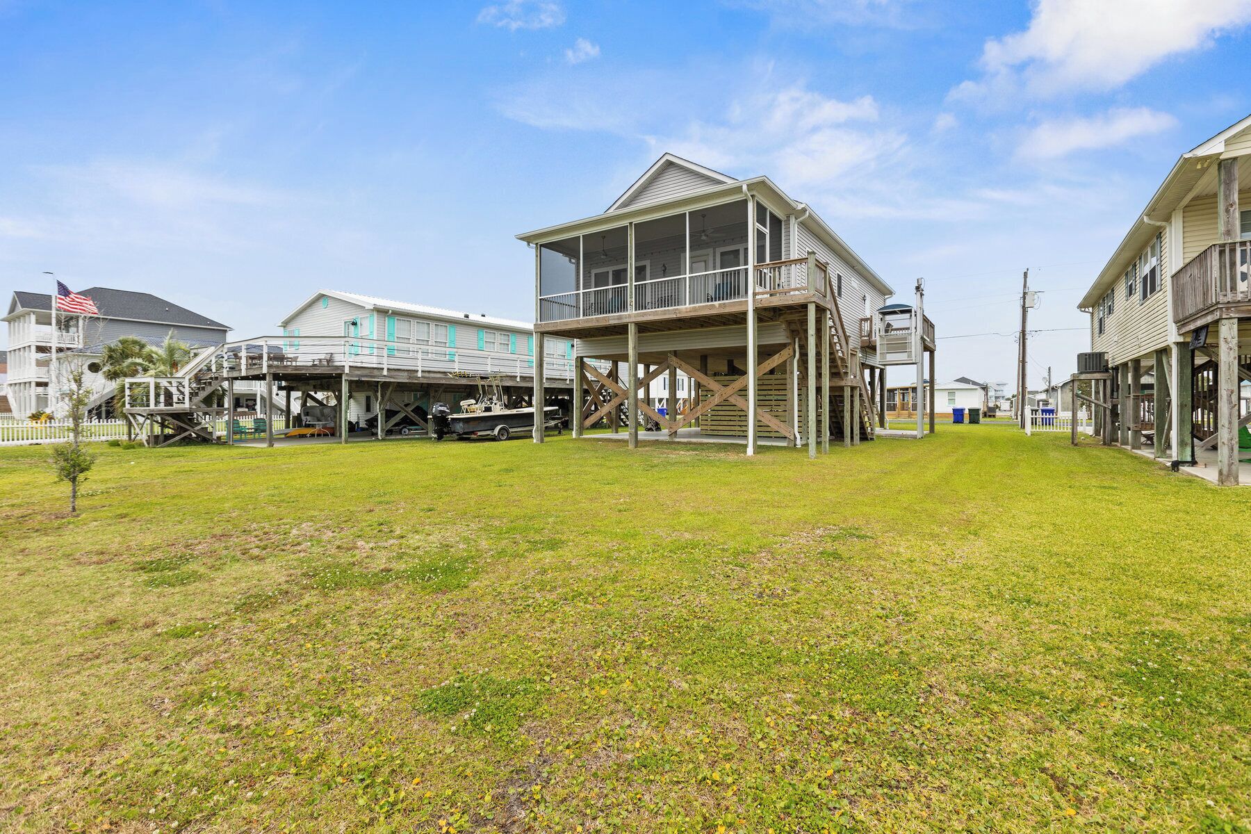 A beachfront house with a covered deck and a boat dock.