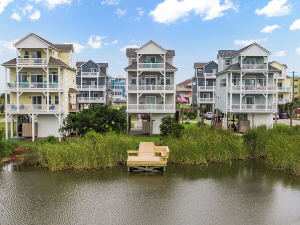 A waterfront residential area with multi-story houses featuring balconies and waterfront views. - Palm Beach North by Topsail Realty (Sneads Ferry)