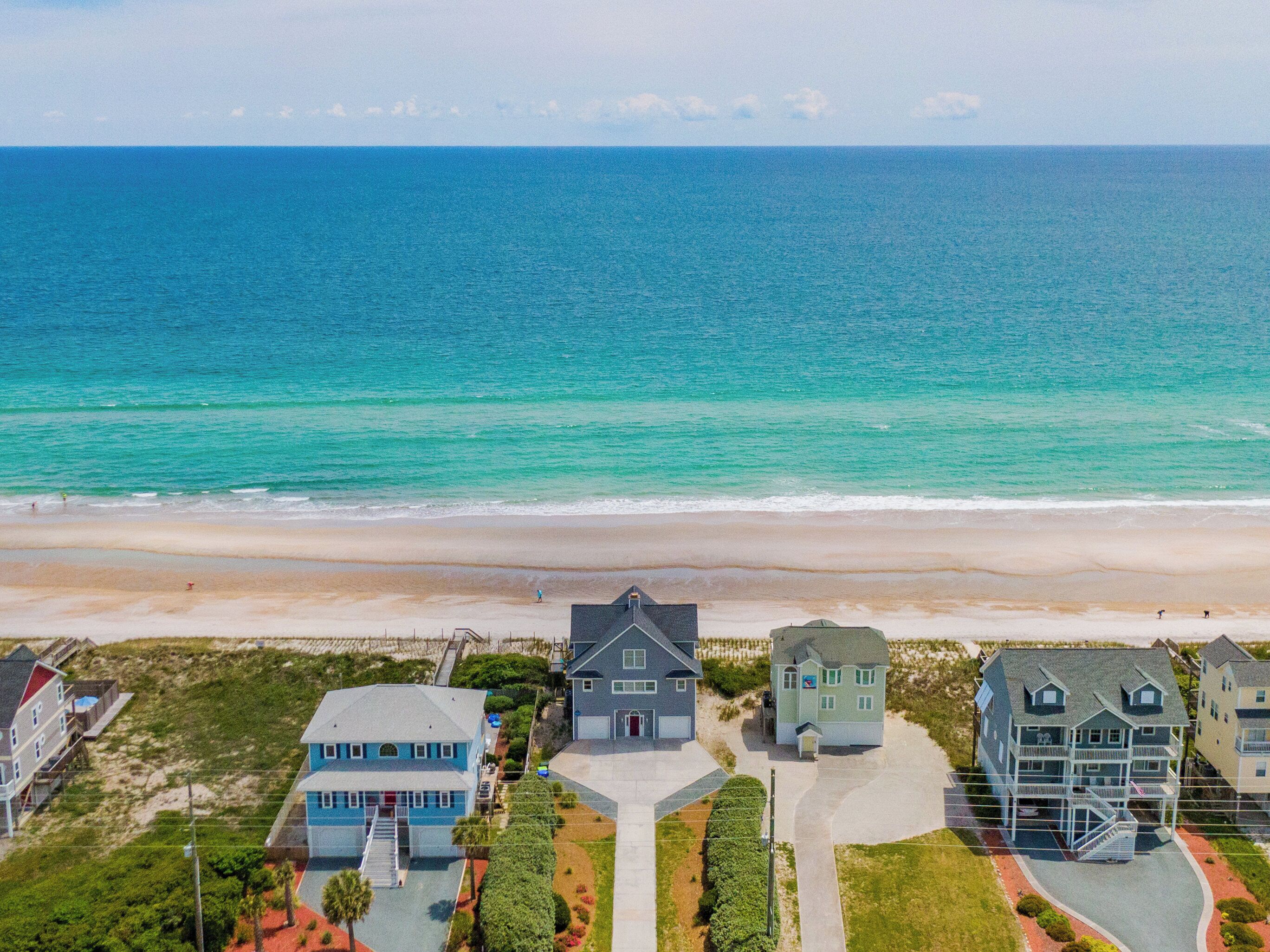 A coastal residential area with houses, a beach, and the ocean.