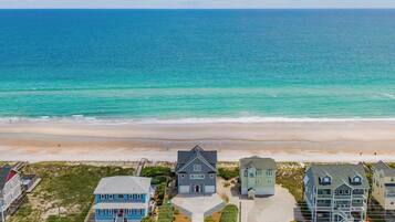 A coastal residential area with houses, a beach, and the ocean.