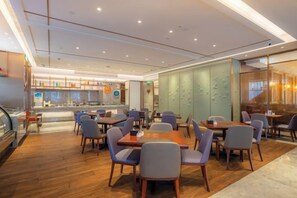 Un restaurant moderne doté d’un bar, d’un espace pour accueillir les clients et offrant une vue sur le paysage urbain.