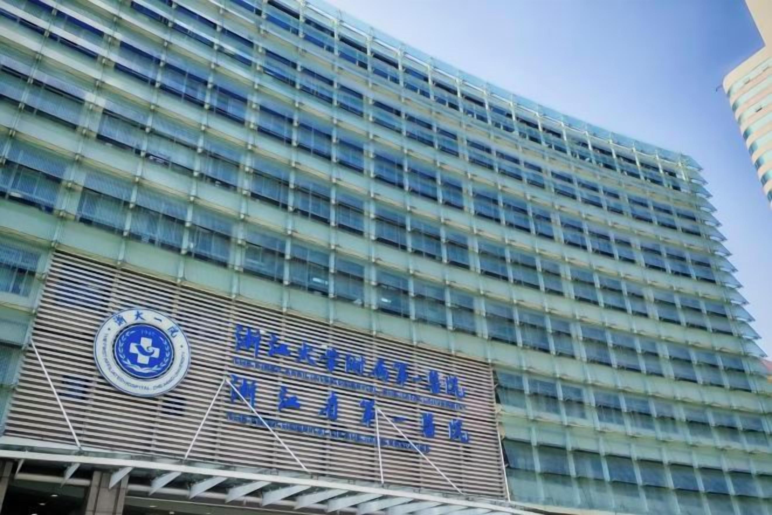 A modern building with a large blue sign and a circular logo.
