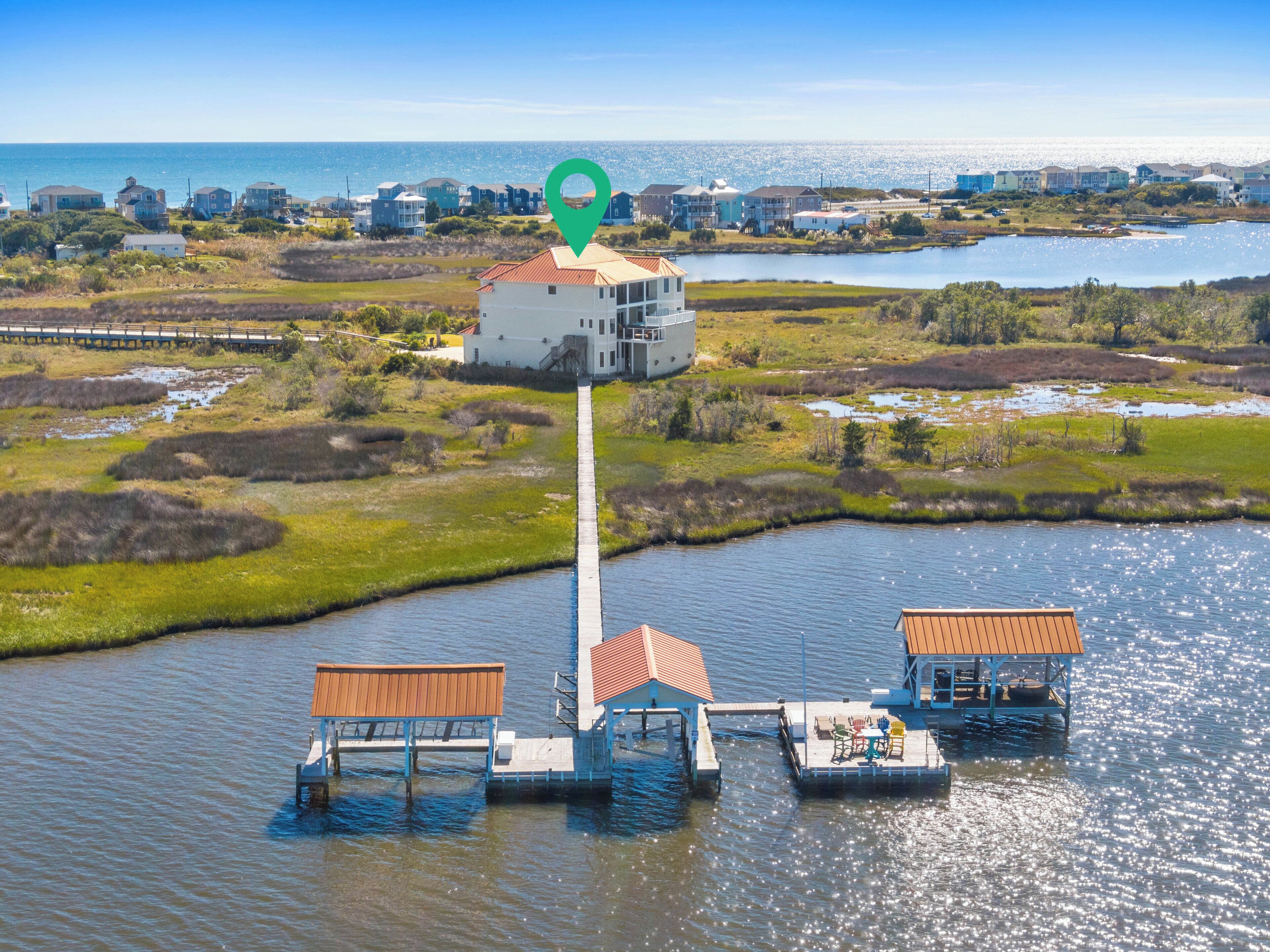 A waterfront property with a central building, connected to floating docks with outdoor seating.