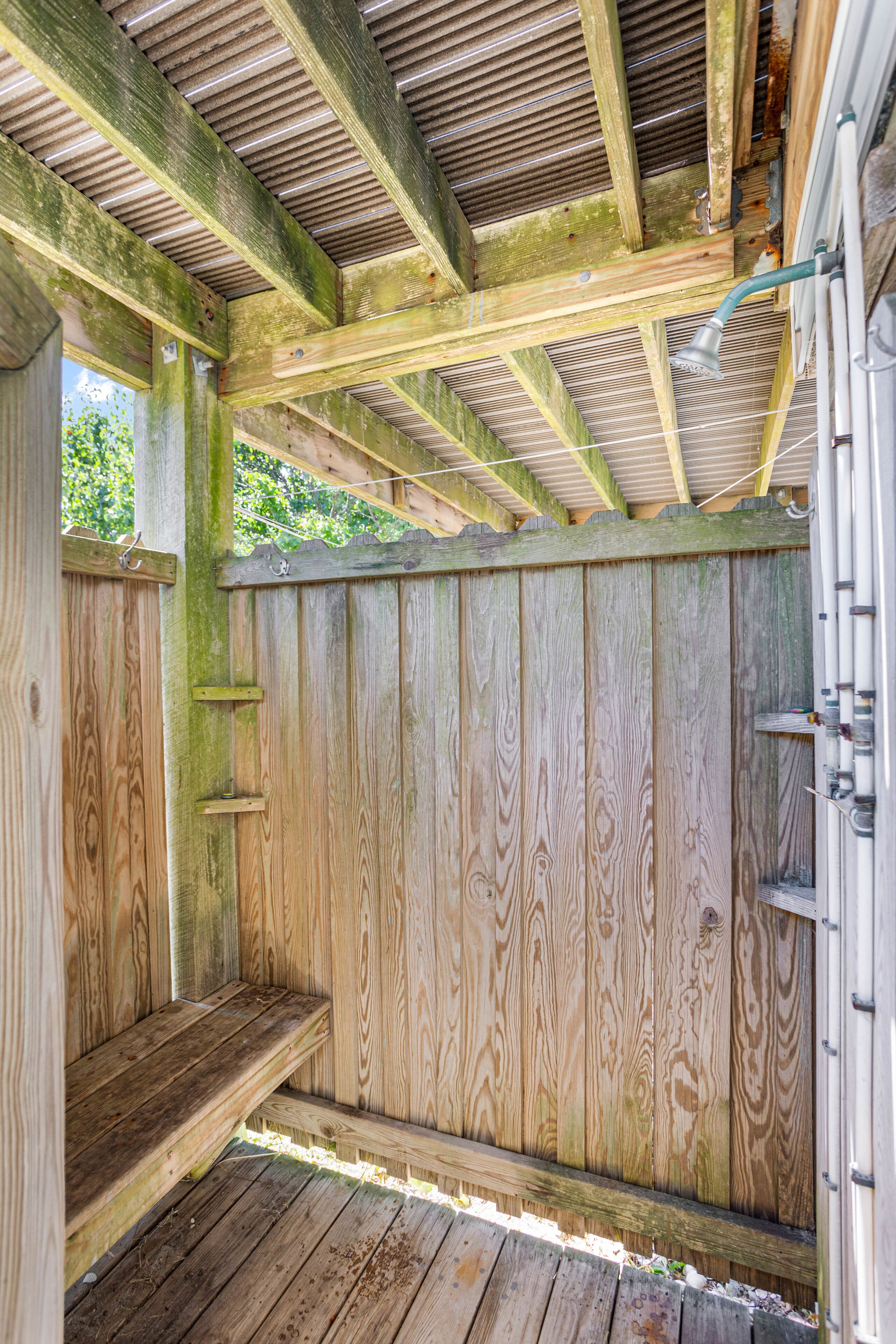 A wooden deck with a bench, a metal railing, and a wooden fence.