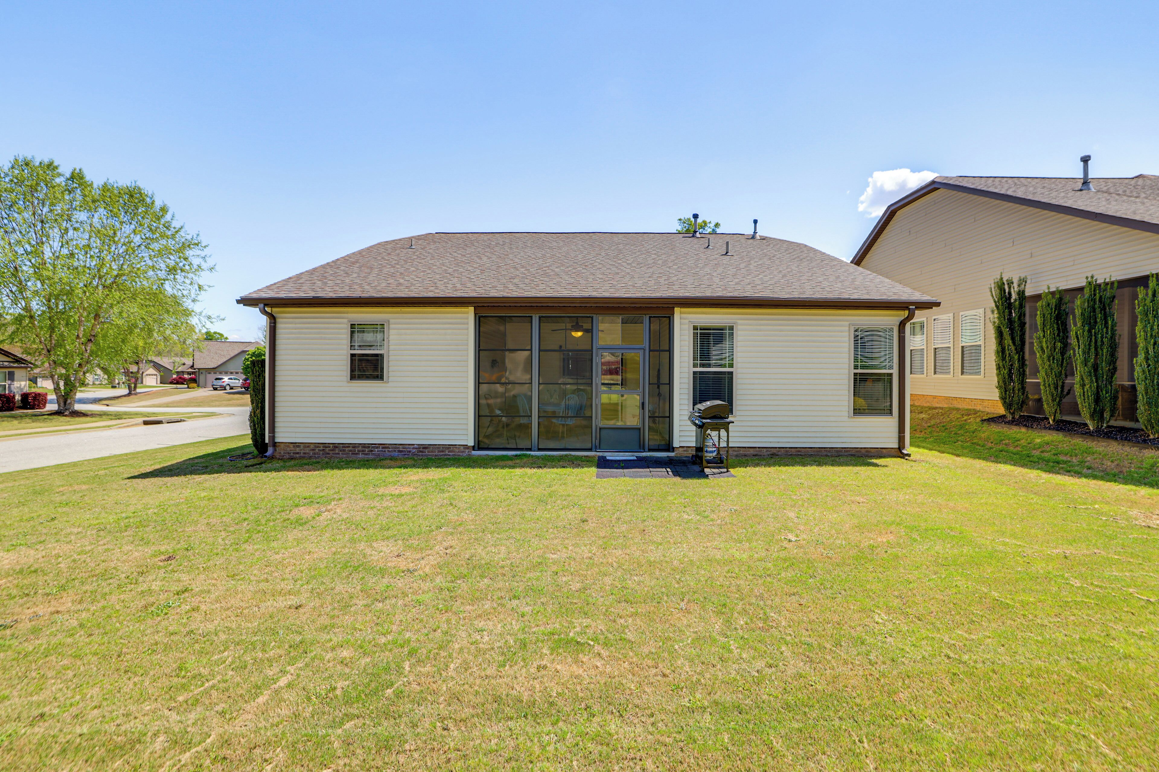 Ein eingeschossiges Haus mit Veranda, Garage und gepflegtem Rasen.