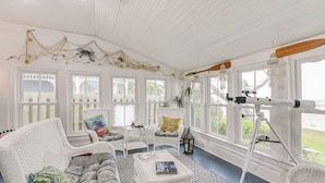 A bright, airy room with white wicker furniture, large windows, and a telescope. - Galveston Bay Retreat: Historic La Porte Home! (La Porte)