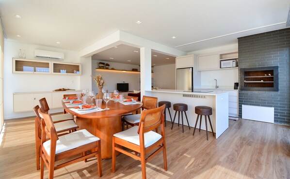Una cocina moderna con una isla central, una mesa de comedor de madera y sillas.