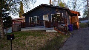 Eine zweistöckige Holzhütte mit Veranda, Treppe und Briefkasten.