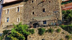 Un edificio de piedra con un balcón, una puerta y una escalera que conduce a un nivel superior.