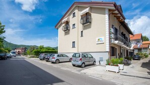 Un hôtel à plusieurs étages doté de balcons, d’un parking et surplombant un paysage montagneux.
