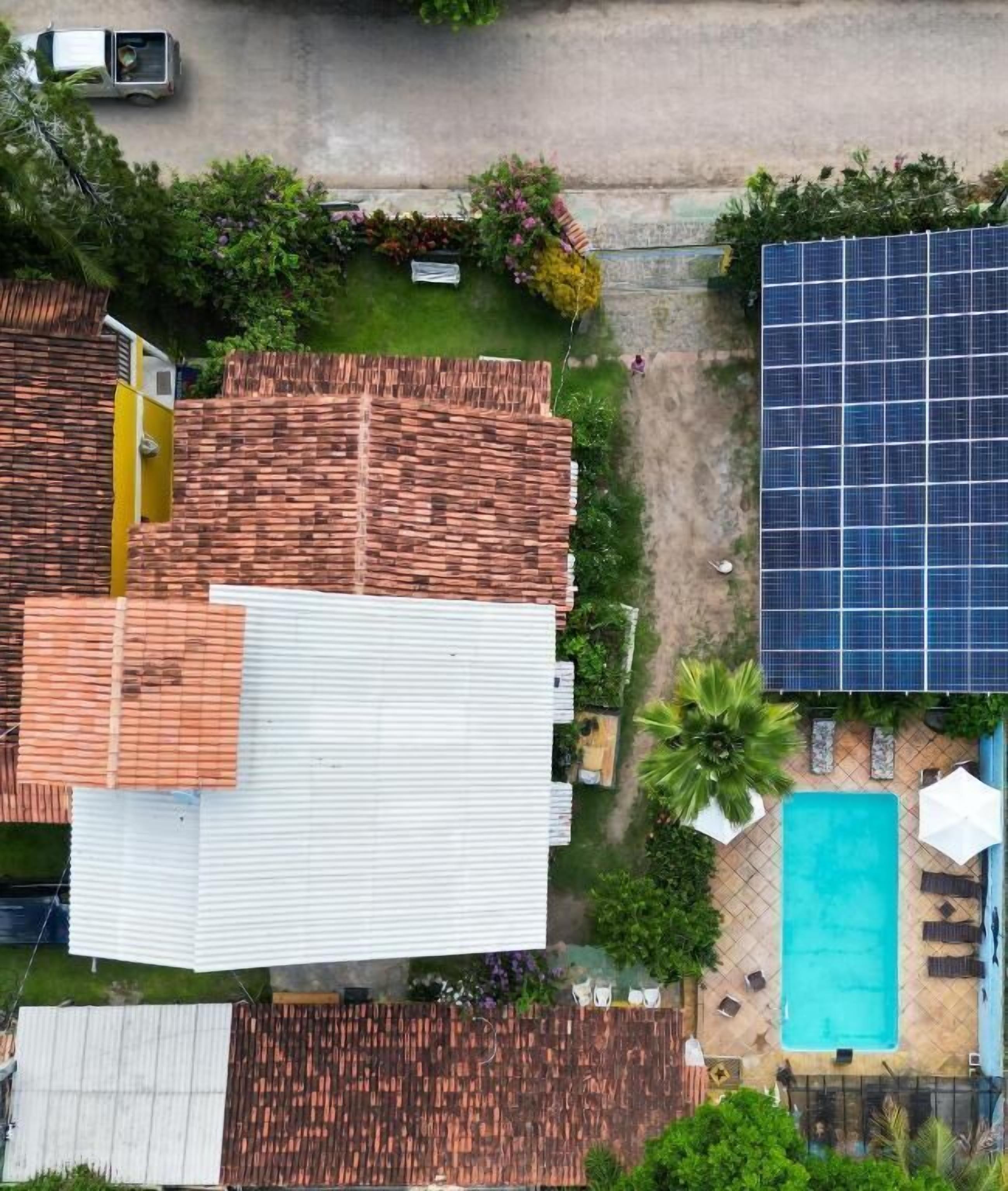 A residential property with a swimming pool, solar panels, and a garden.
