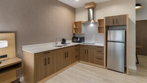 Una cucina moderna con mobili in legno, un frigorifero in acciaio inossidabile, un forno a microonde e un forno integrato.