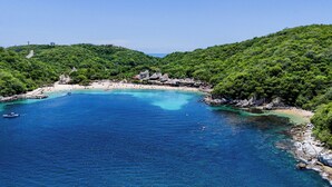 A coastal area with a beach, clear blue waters, and lush green hills. - Suites La Playa (Santa Maria Huatulco)